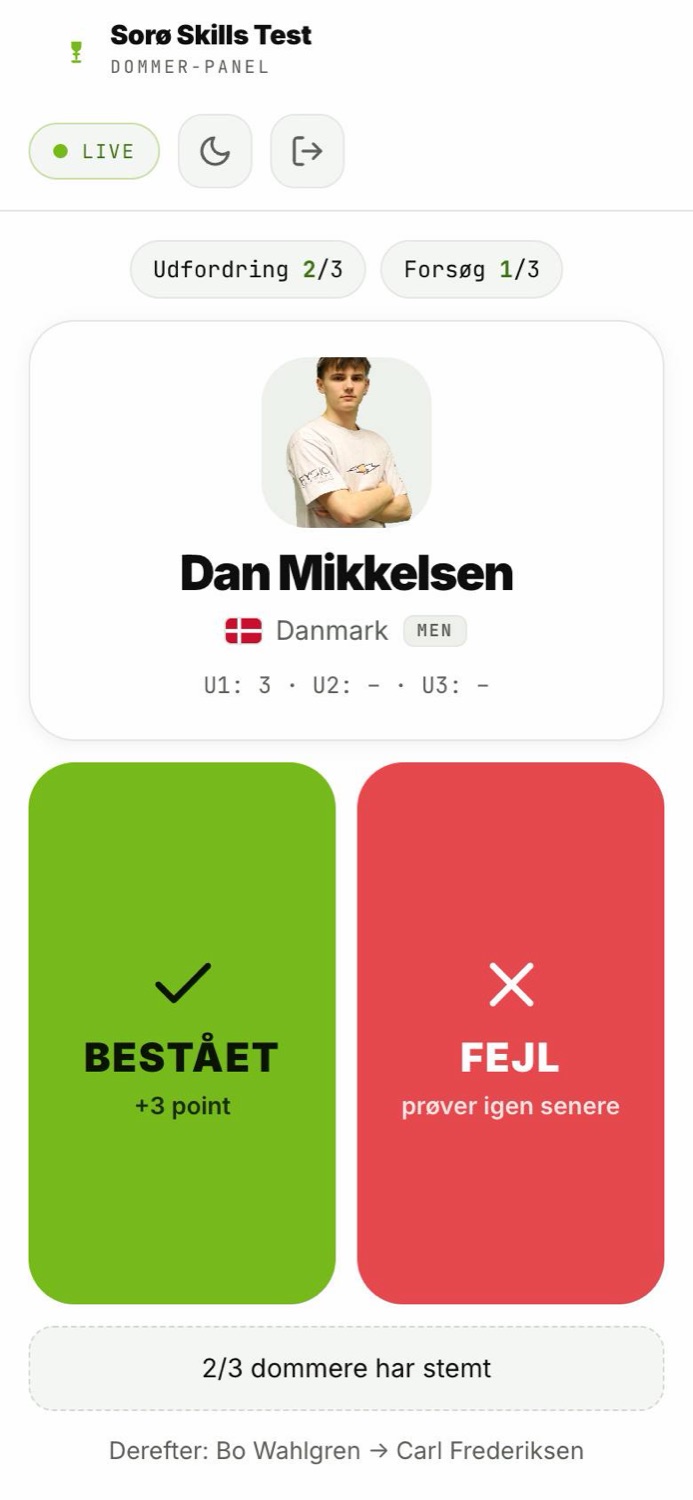 Dommerpanelet på en telefon med atleten på banen og to store knapper: Bestået og Fejl.